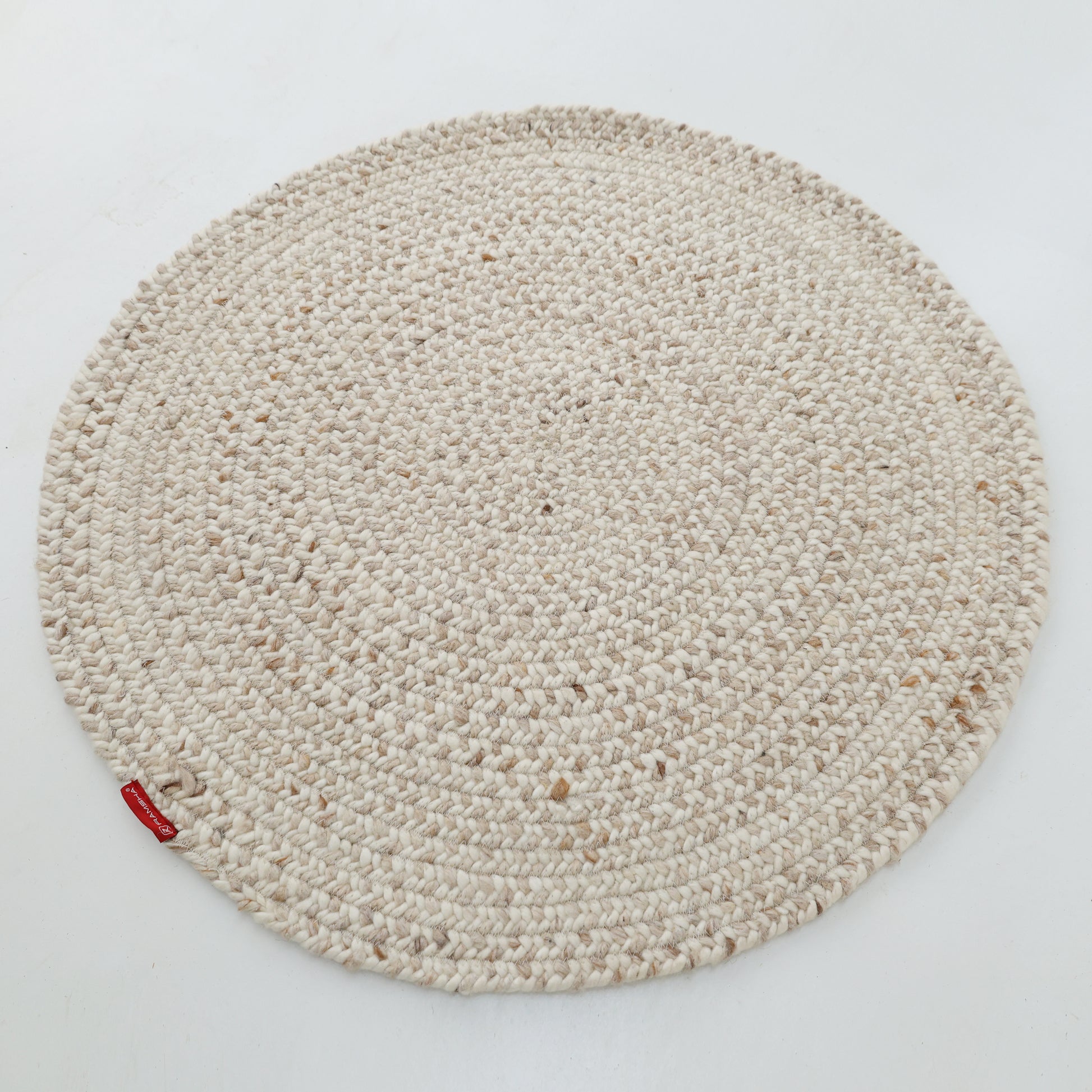 The RAMSHA HOME Natural Color Home Decor Round Jute Rug - BR 095, beige-toned, is shown on a plain white background with a small red tag attached to its edge.