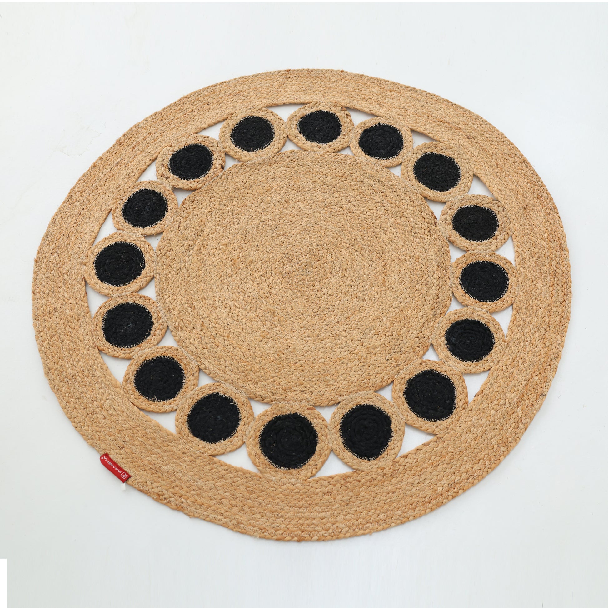 The RAMSHA HOME Jute Natural Rug Round Natural & Black BR-050 features a natural tan hue with braided jute and evenly spaced black circles near the edge, creating a subtle accent against its round design.