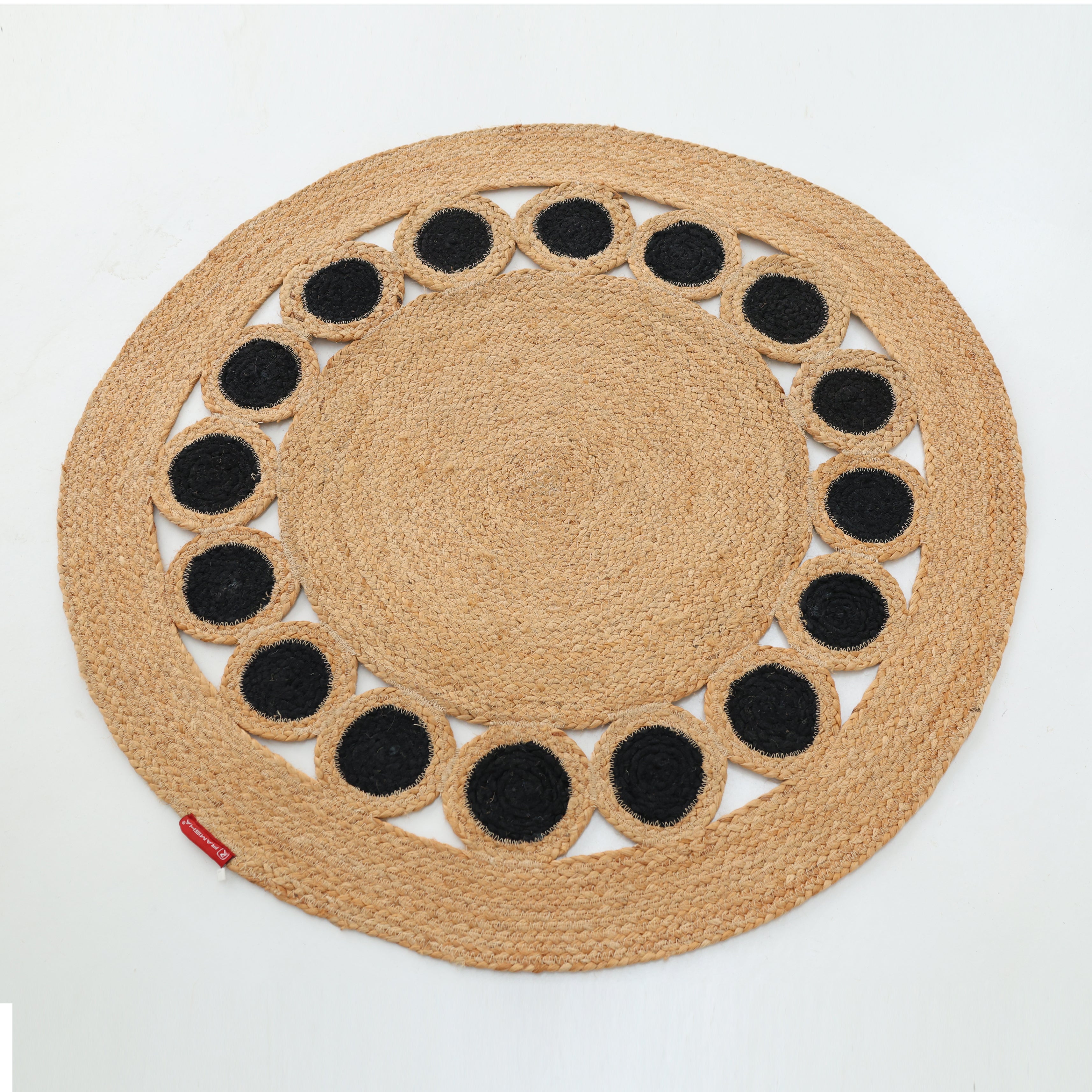 The RAMSHA HOME Jute Natural Rug Round Natural & Black BR-050 features a natural tan hue with braided jute and evenly spaced black circles near the edge, creating a subtle accent against its round design.
