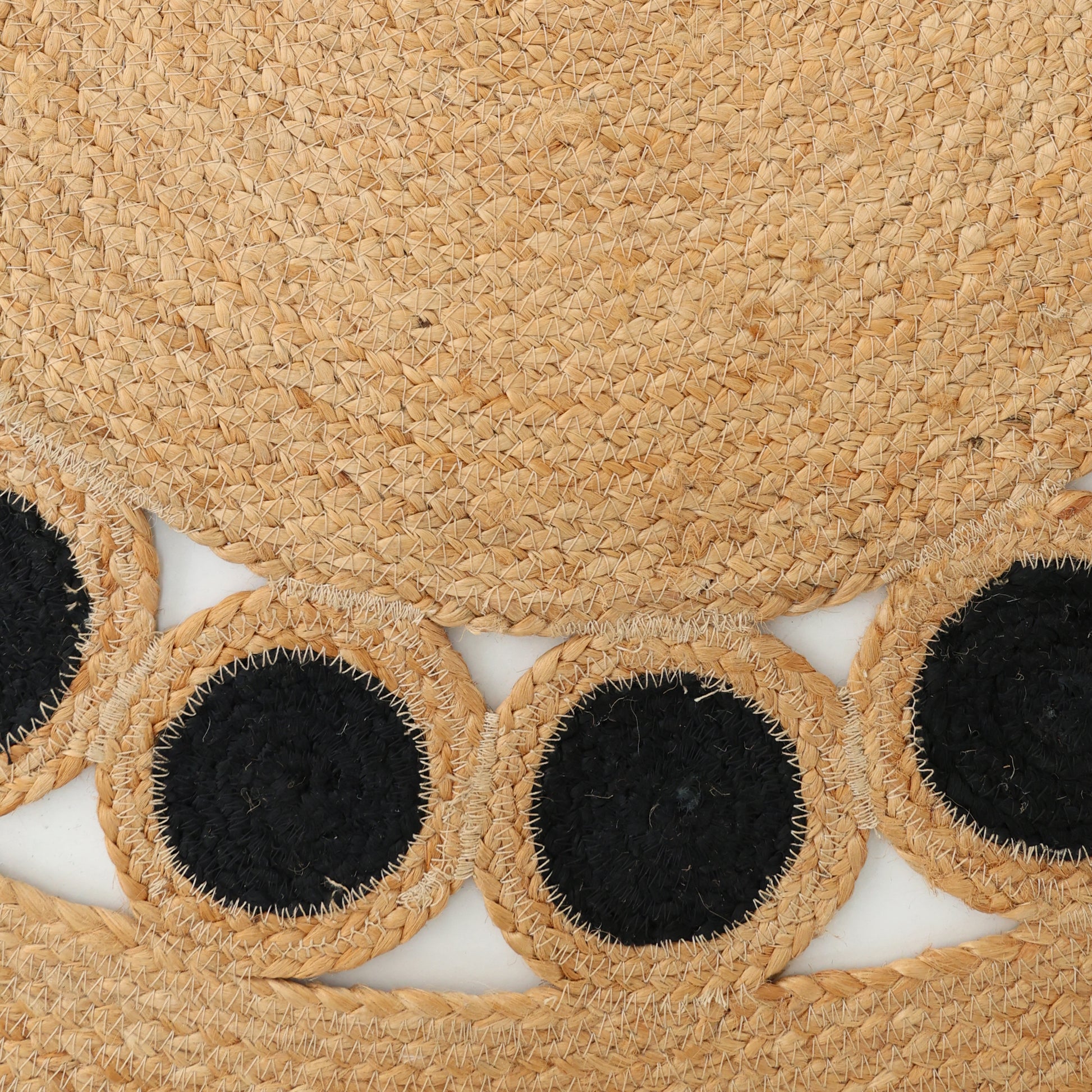 Close-up of the RAMSHA HOME Jute Natural Rug Round Natural & Black BR-050, showing its braided jute design with large natural circles featuring black centers along the rug’s edge.