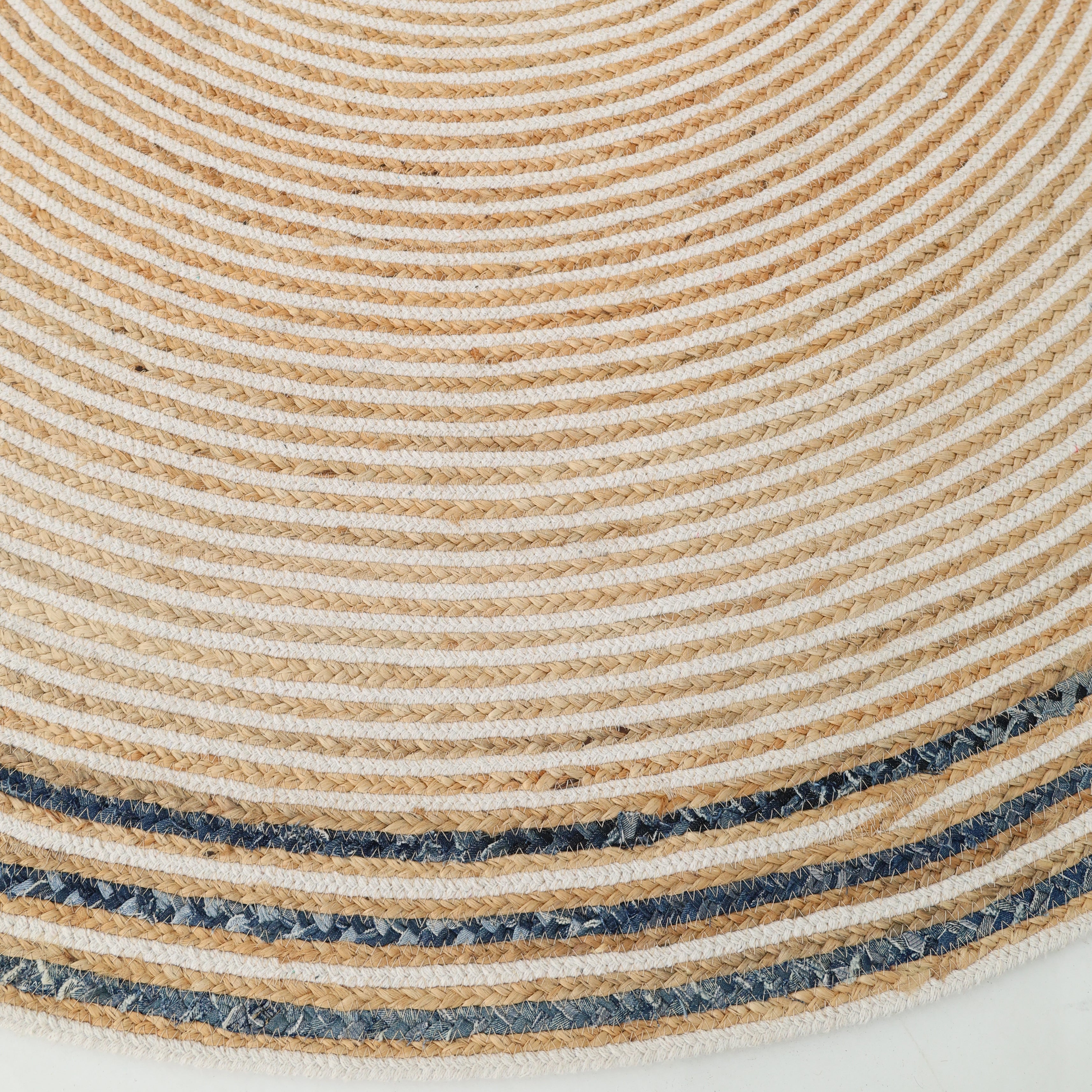 Close-up of the RAMSHA HOME Creative Handcrafted Blue Border Braided Rug - BR 065, a round rug with concentric beige and off-white rings and dark blue patterned borders, adding texture and style to any space.