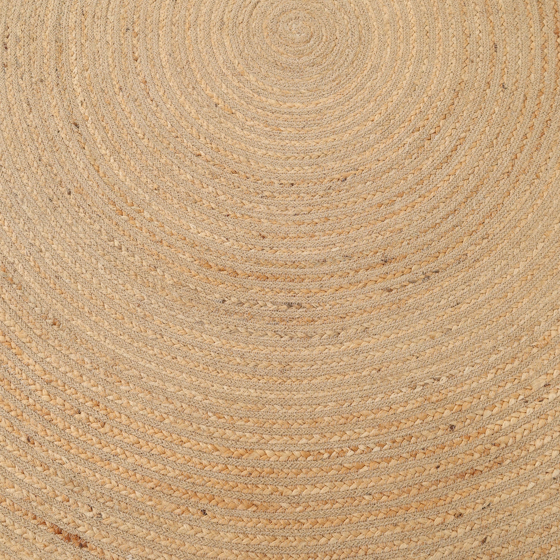 A close-up of the RAMSHA HOME Luxurious Handmade Home Decor Jute Rug Circle - BR 088, featuring braided natural jute fibers in elegant beige and light brown with concentric circular patterns.