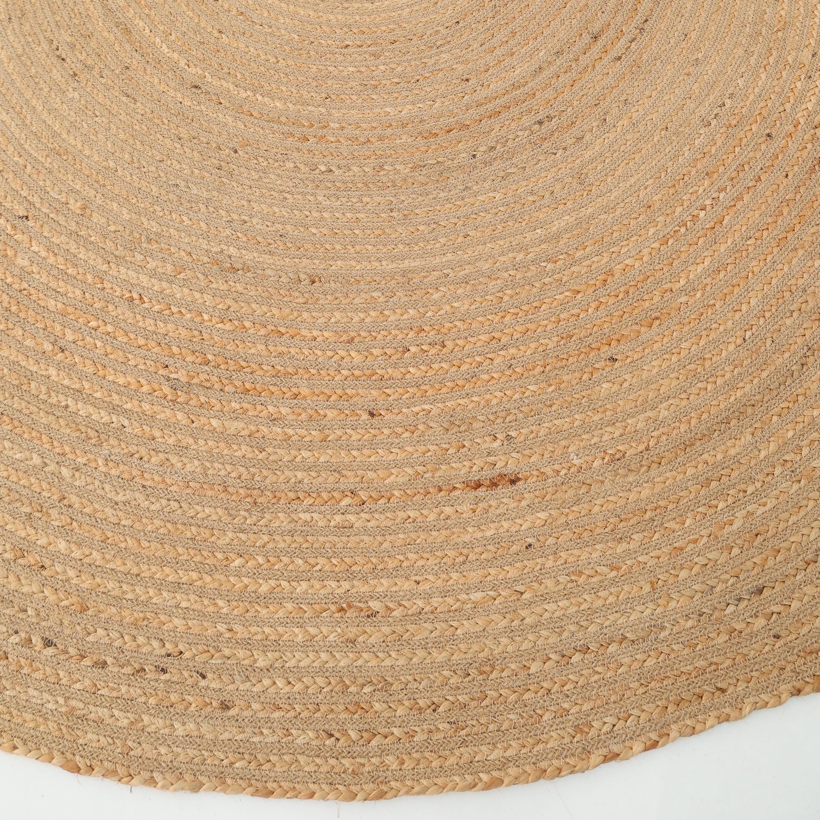 A close-up of the Luxurious Handmade Home Decor Jute Rug Circle - BR 088 by RAMSHA HOME highlights its textured, woven beige pattern and round braided design on a white background.