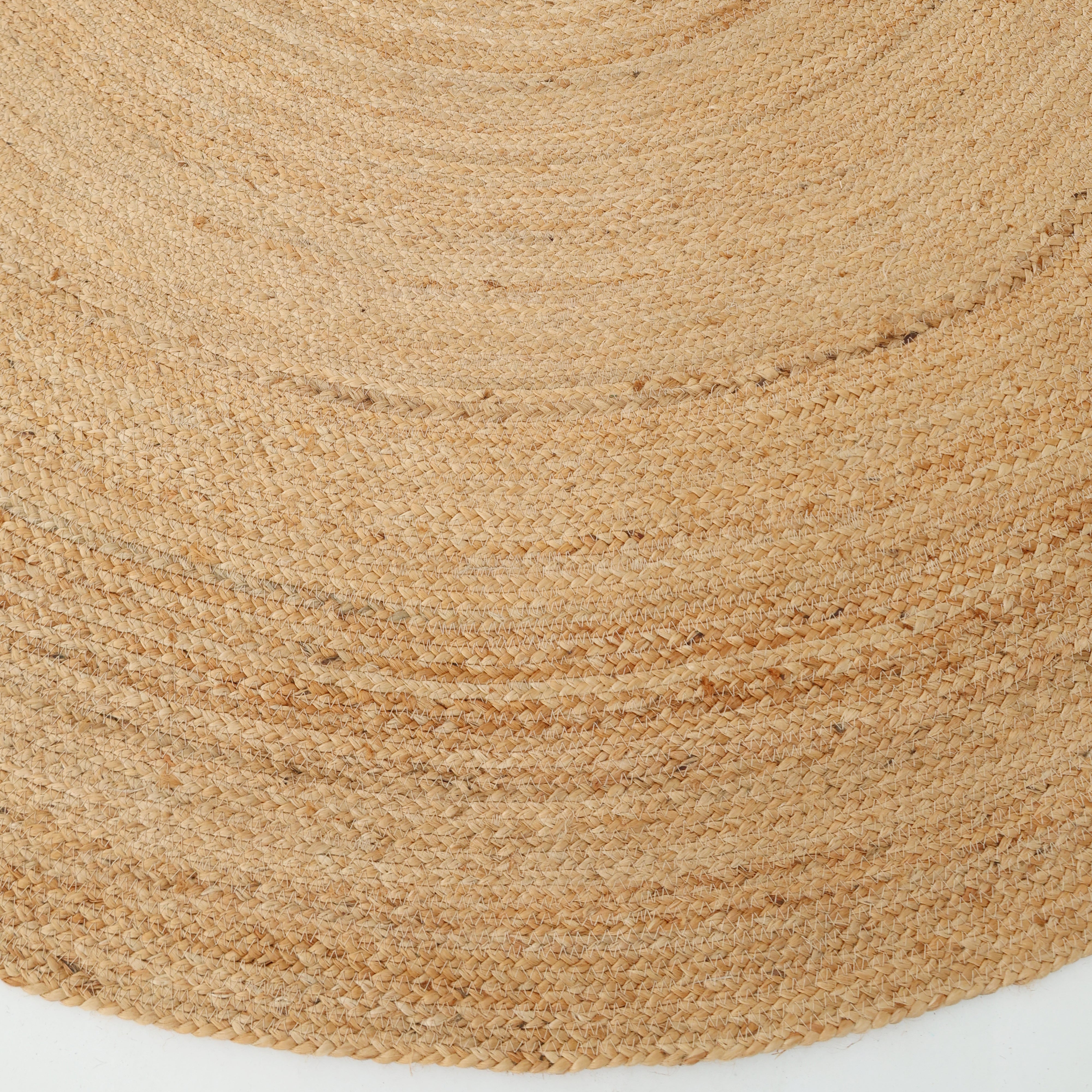 Close-up of the RAMSHA HOME Handmade Jute Braided Rug BR-016, an oval natural area rug with a subtle spiral pattern in tan and beige tones, showing its textured surface as it lies on a white background.