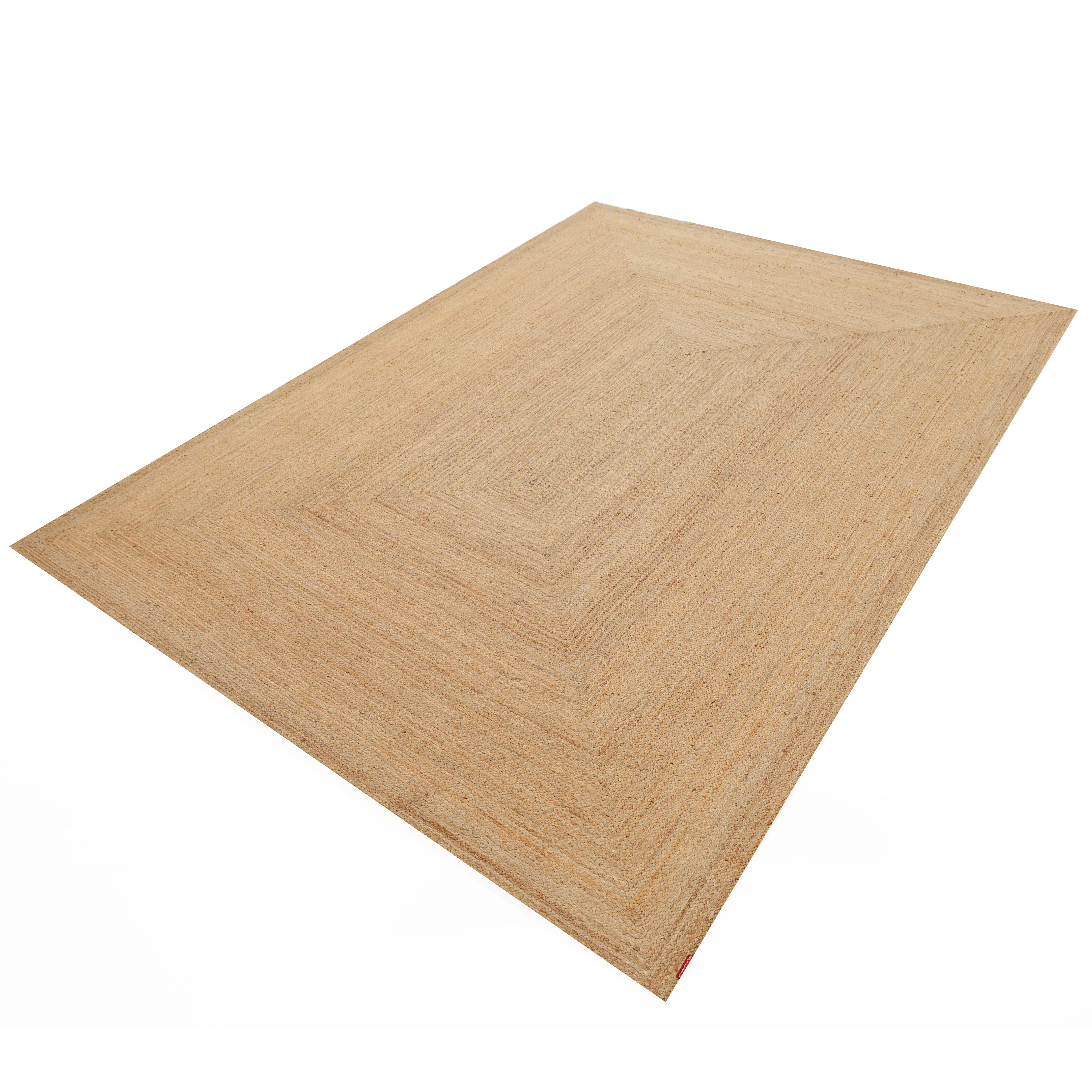 The Handmade Natural Color Drawing Room Jute Floor Braided Rug - BR 046 is a large, rectangular, light brown rug with a subtle pattern, crafted from natural jute and shown on a white background.