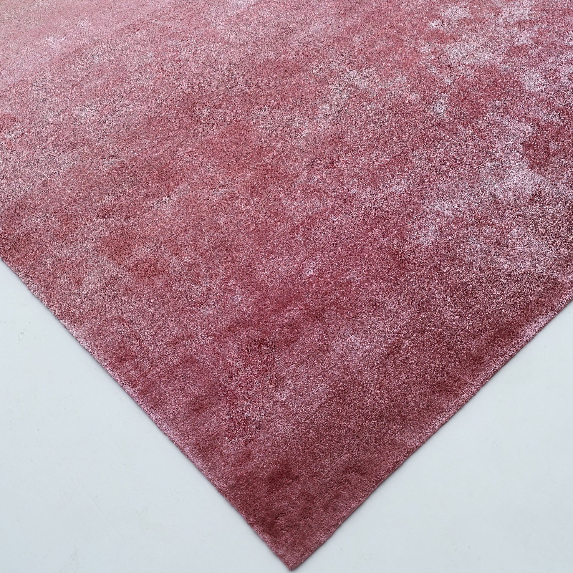 A close-up of the RAMSHA HOME Rose Ombre Handmade Area Rug HTV 27 (300x400 cm), a large rectangular pink gradient rug with a soft, velvety texture, shown on a light-colored floor.