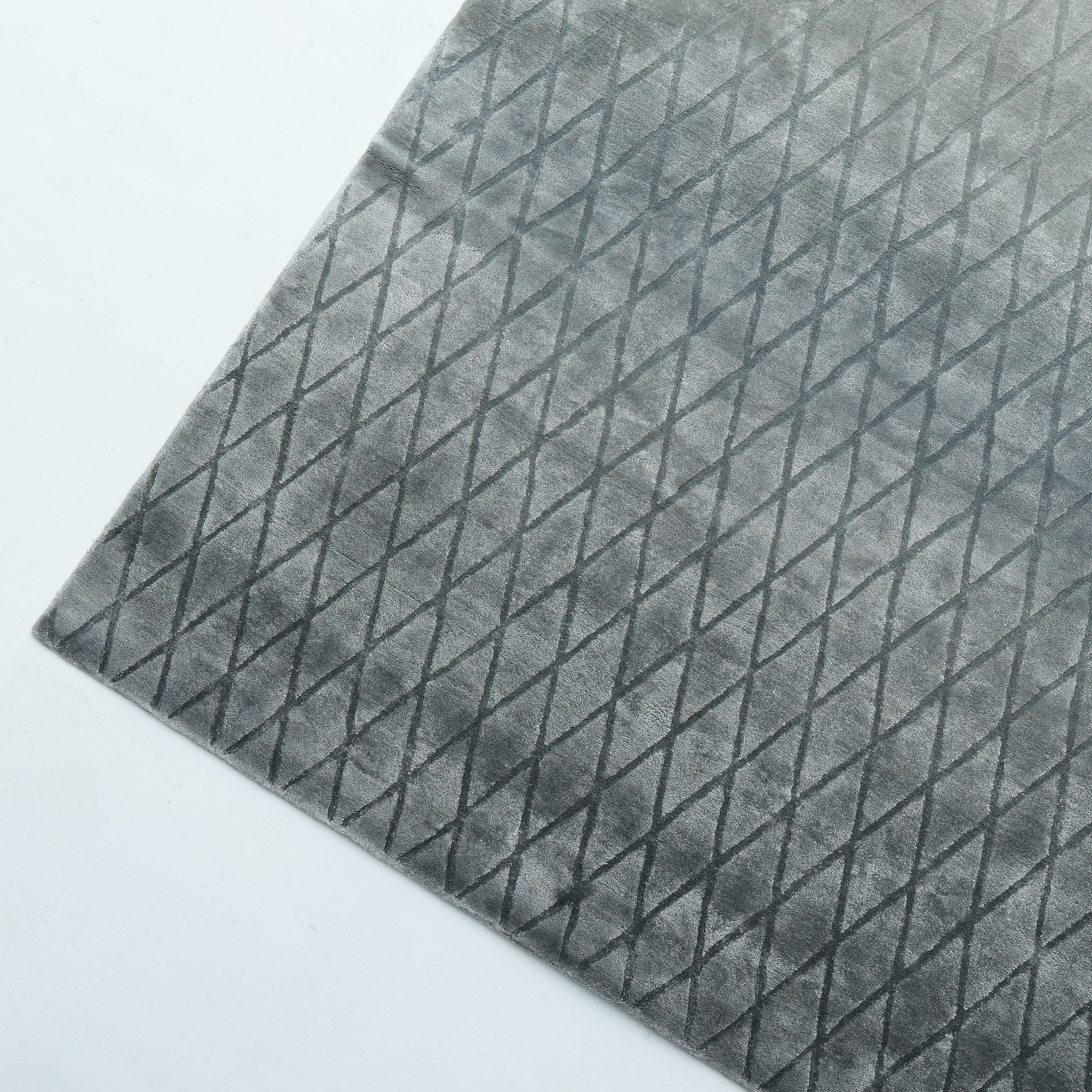The RAMSHA HOME Steel Diamond Handmade Rug HTV 28 (300x400 cm) is a gray rectangular rug with a subtle diamond pattern, shown from an angled top-down view. This modern piece brings sophisticated style to any room.