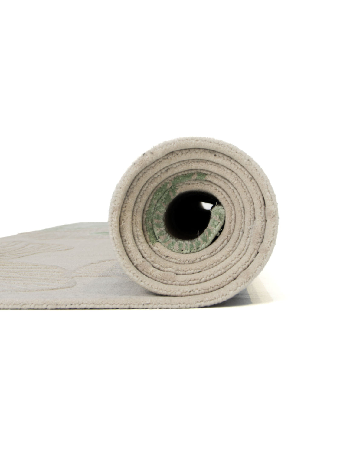A side view of the RAMSHA HOME Floral Handmade Rectangle Rug HTWV-189 in beige shows the rug partially rolled up, revealing its circular layers. The artisanal craftsmanship is highlighted by the clearly visible texture and thickness of this hand-woven piece.