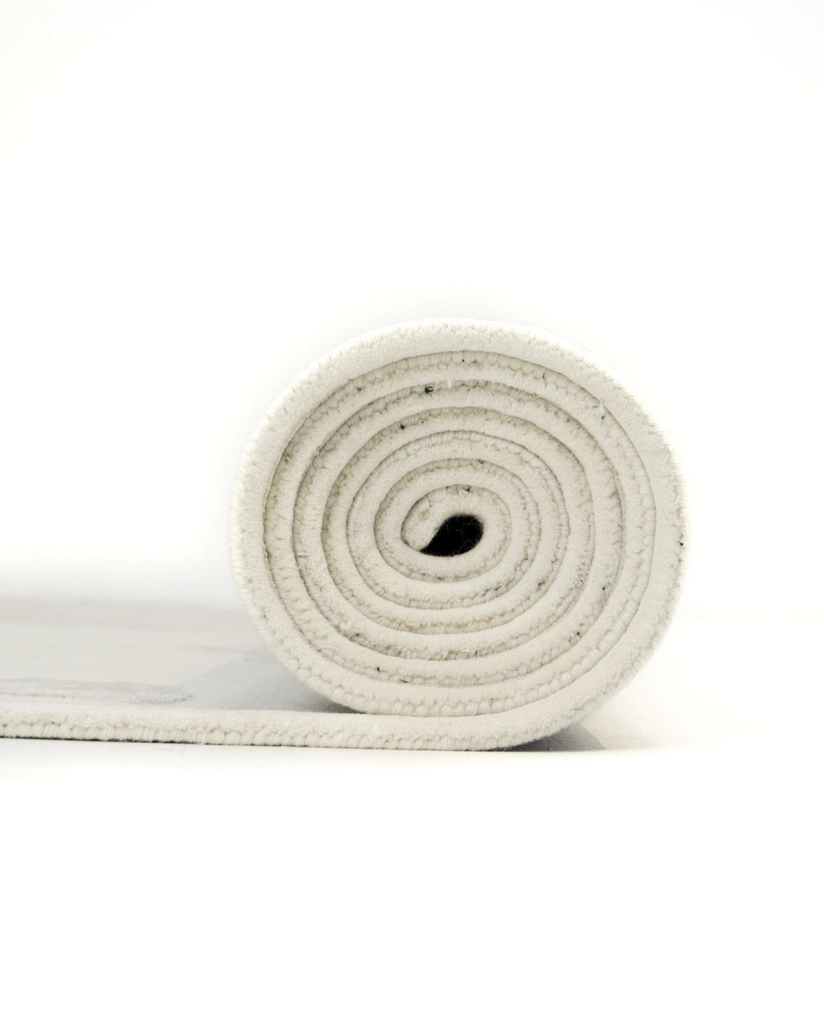A close-up side view of the RAMSHA HOME Multi Color Handmade Area Rug - HTWV-132, rolled up on a white background, with soft textures reminiscent of a handtufted rug.