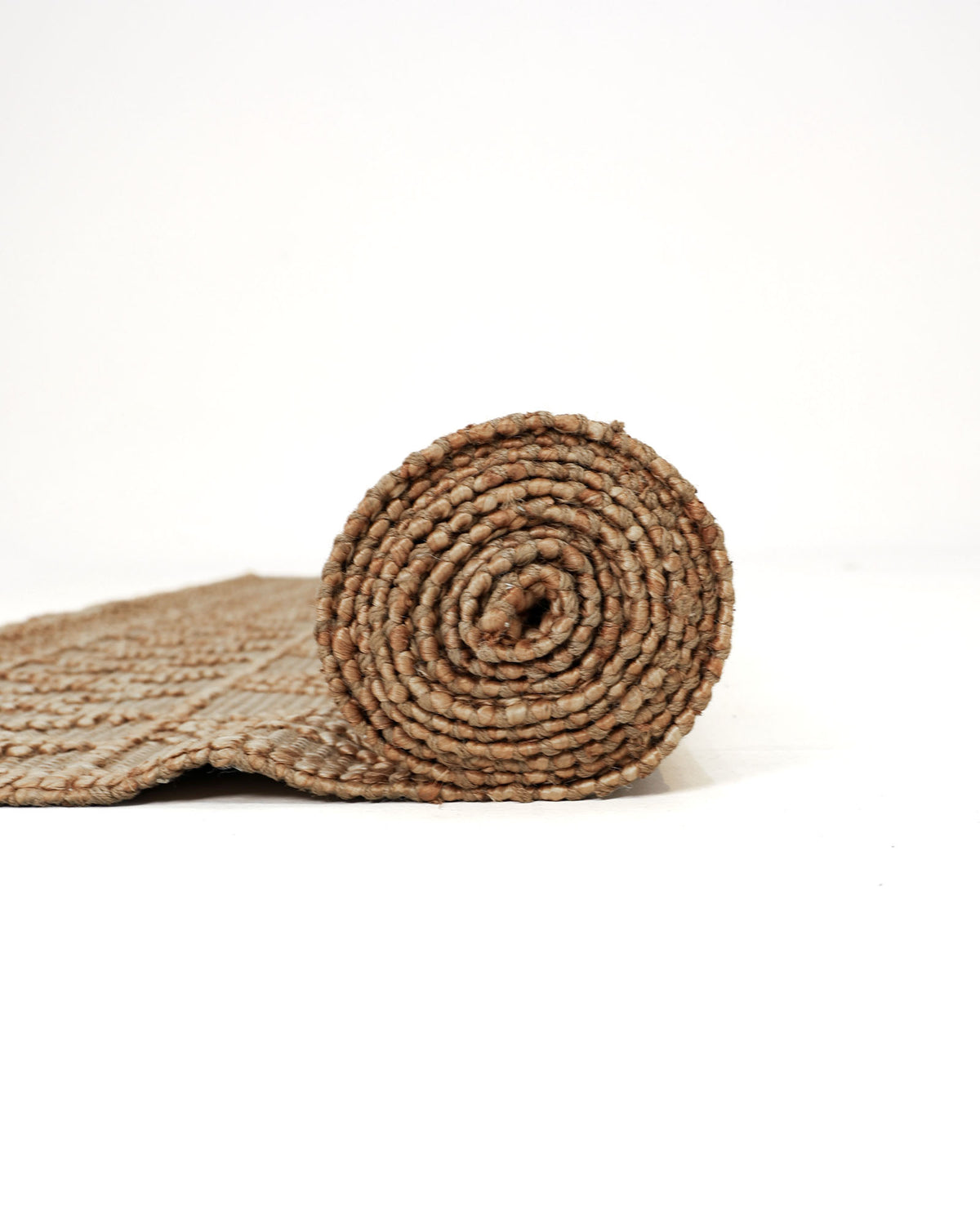 The RAMSHA HOME Floor Woven Living Room Rug (Natural Color, Rectangle Shape, SR-019) is partially unrolled on a white surface, with the rolled end facing the camera and its textured pattern clearly visible.