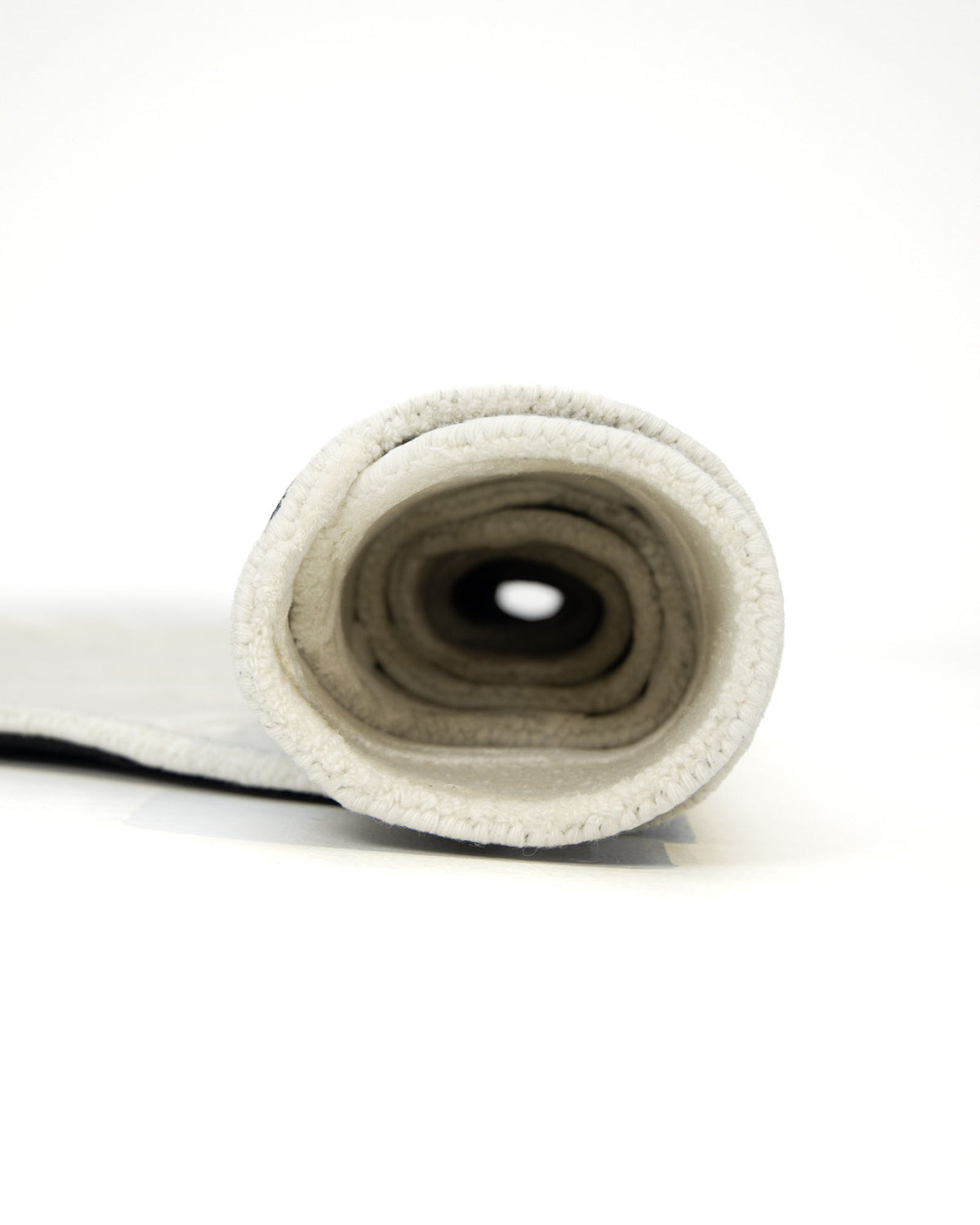 A rolled-up Premium Beige Handmade Carpet HTWV-100 (200×300 cm) by RAMSHA HOME is shown standing on one end against a white background, revealing its inner layers.