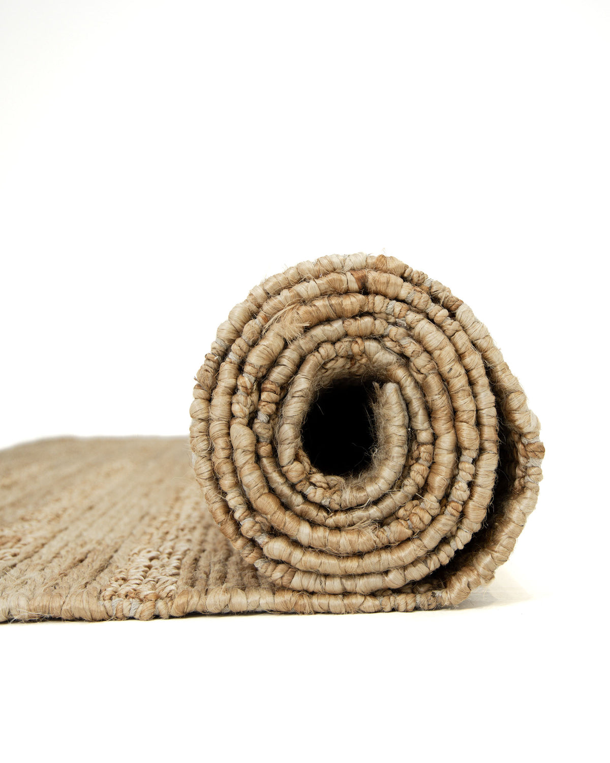 Here’s a rewritten version incorporating your product data: A close-up of the RAMSHA HOME Natural Color Hand Woven Jute Rug SR-043, rolled up on a white background. The hand-woven spiral layers and textured surface are prominently displayed, highlighting the earthy tan and beige tones of its natural jute fibers. This rug makes an elegant addition to any space and serves as a thoughtful Ramadan gift option.