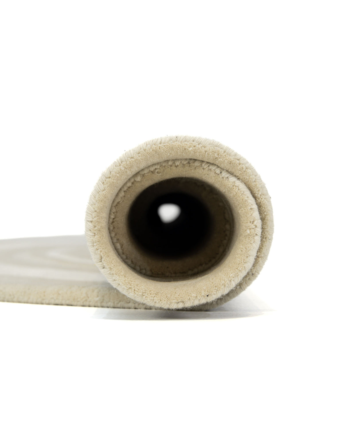 Close-up view of the RAMSHA HOME Multi Color Handmade Rug - HTWV-120, shown rolled up with its circular shape facing the camera against a white background.