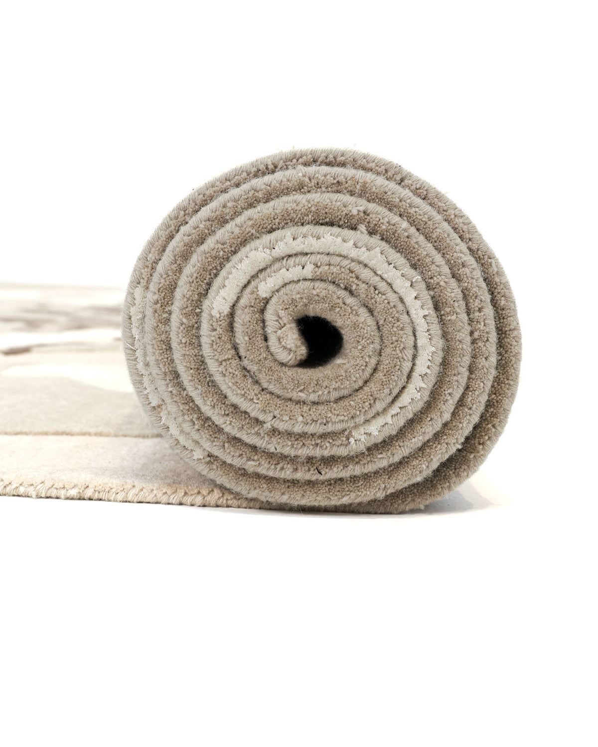 A close-up of the Abstract Wool & Viscose Handmade Carpet 300x400 – HTWV-180 by RAMSHA HOME, rolled up on a white background, highlights its beige hand-tufted construction, spiral pattern, and soft carpet fibers.