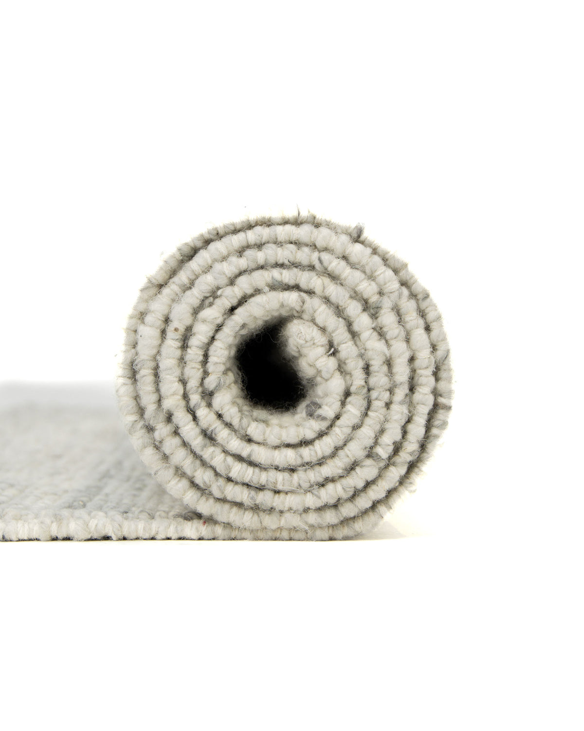 A close-up side view of the RAMSHA HOME Soft Terra Flatweave Wool Rug (SRN-043) in light grey, showcasing its textured, handmade design tightly rolled against a white background.