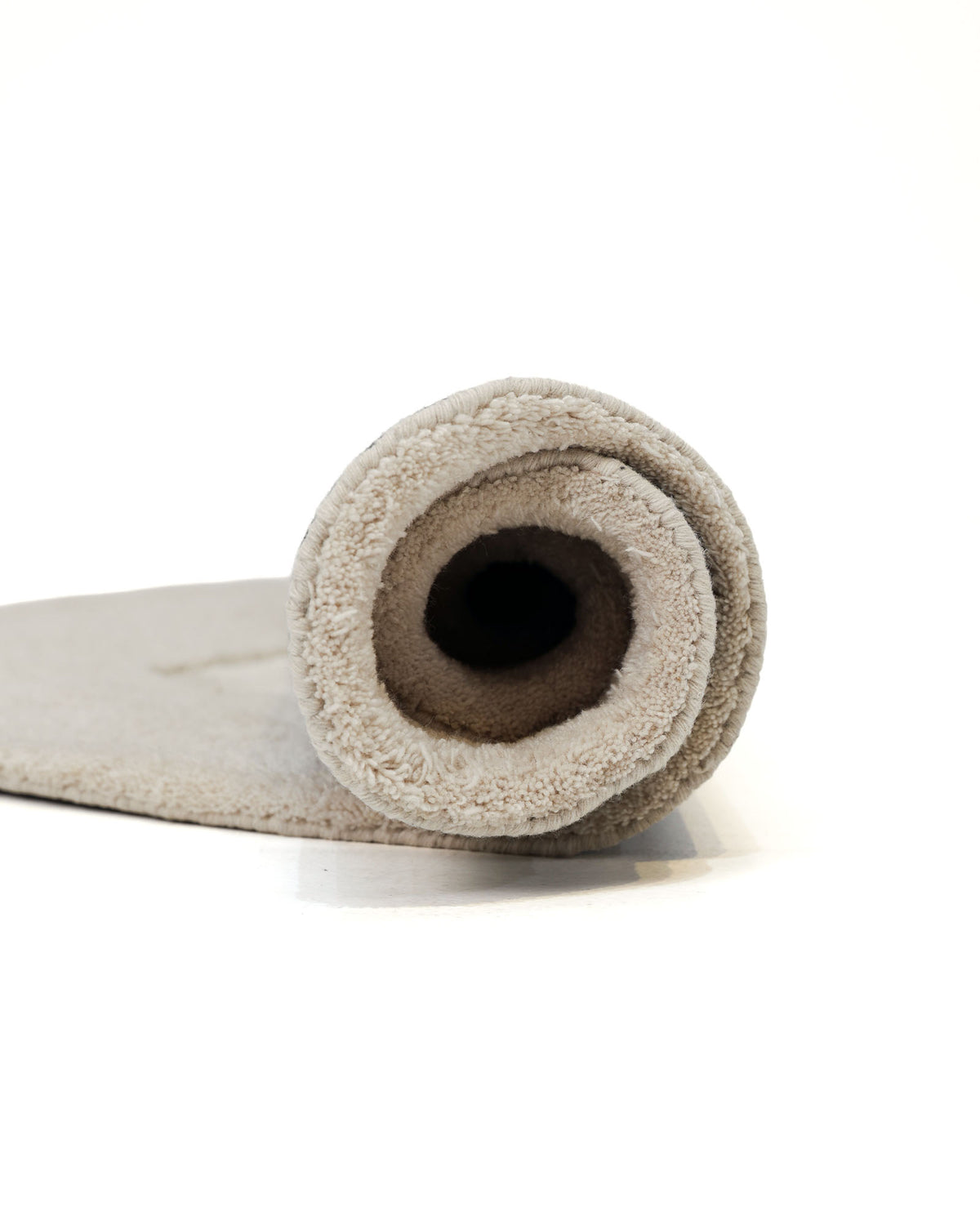 A multi-colored, handmade area rug from RAMSHA HOME (HTWV 148) is rolled up on a white background, with the rolled end facing the camera.