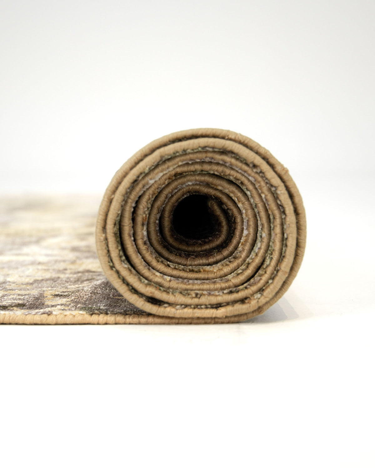 A rolled-up RAMSHA HOME Hand Knotted Abstract Vintage-Inspired Bamboo Silk Rug (KNTC 22-200x300 CM), featuring a beige and brown pattern, sits on a white surface with its open end facing the camera.