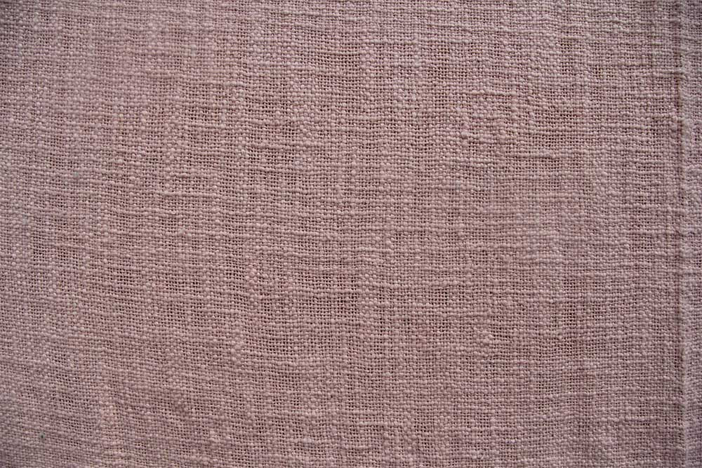 Close-up of Ramsha Home’s Pink Color Cotton Throw for Sofa TAL 042 (125x150 cm), showing its textured woven pattern. The natural cotton fabric looks breathable and comfortable, enhancing your space with luxury by this UAE home furnishings brand.