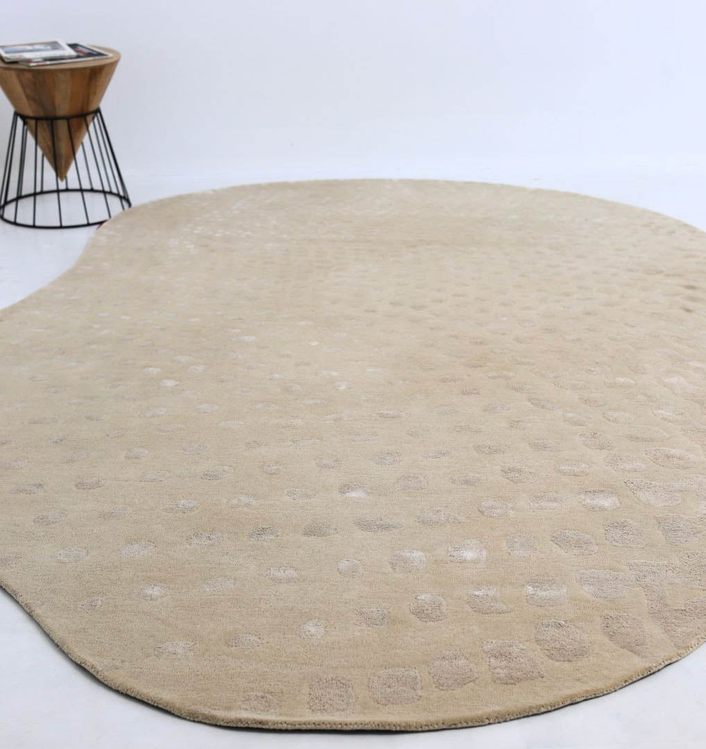 The RAMSHA HOME Shape Floor Rug Multi Color HTWV 93 (200x300 cm) adds style with its large, irregular design and subtle patterns on a white floor. A small round wood-and-metal side table in the corner holds several magazines.