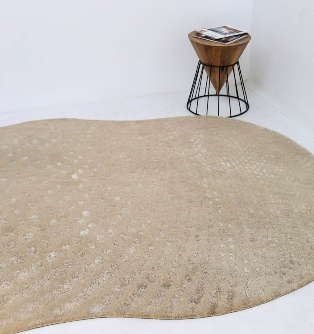 The RAMSHA HOME Shape Floor Rug Multi Color HTWV 93 (200x300 cm) is hand-tufted with a subtle dotted pattern and sits on a white floor beside a small wooden side table holding magazines.