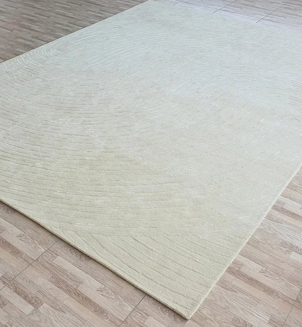 The RAMSHA HOME Luxurious Multi Color Wool & Cotton Handmade Rug - HTWV 64 (300x400cm), a large, rectangular handtufted piece in beige with subtle concentric lines, lies on a light wood-patterned floor.