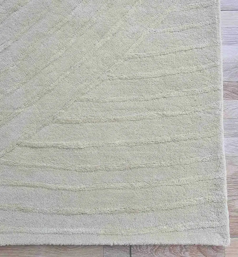 A close-up of the RAMSHA HOME Luxurious Multi Color Wool & Cotton Handmade Rug - HTWV 64 (300x400cm) shows its textured pattern on a light wooden floor, with just a corner of the modern rug and floor in view.