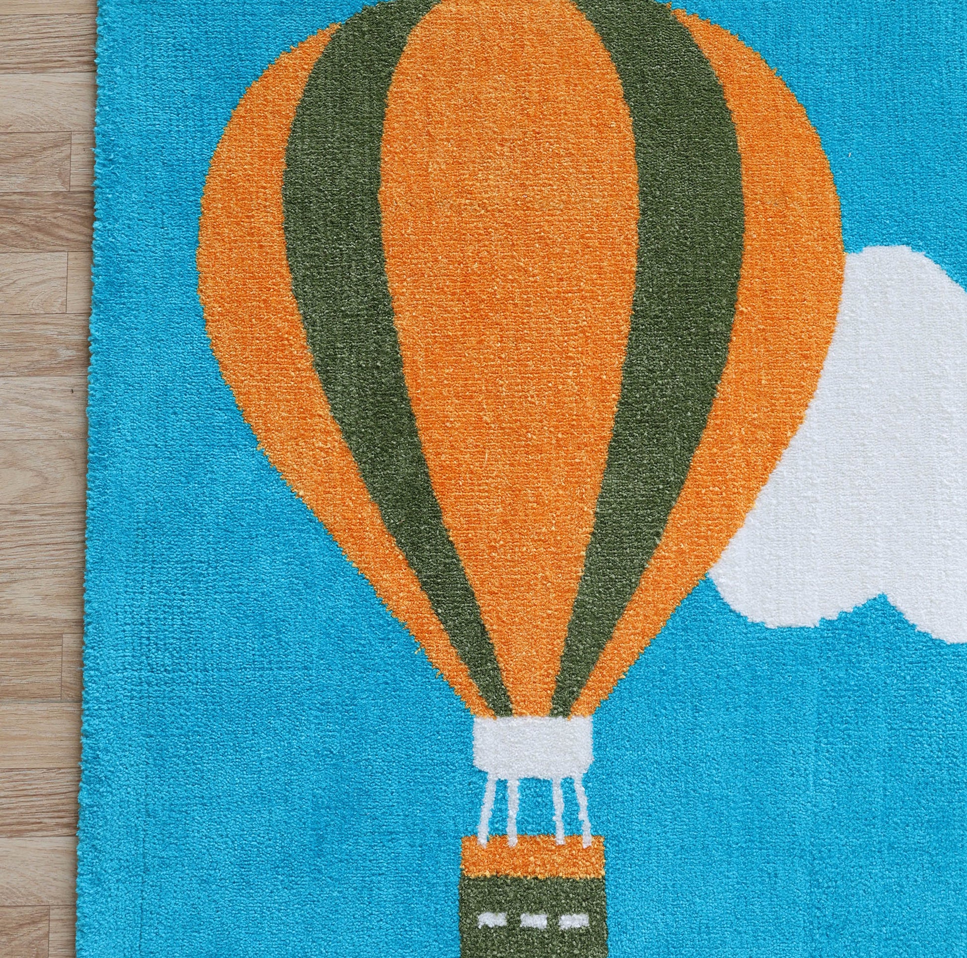The RAMSHA HOME Kids Play Rug with Clouds & Balloons (CMN 101, 200x300 cm) features vibrant balloons and clouds in a bright blue sky, adding charm to any nursery or kids' room—perfect for wooden floors.