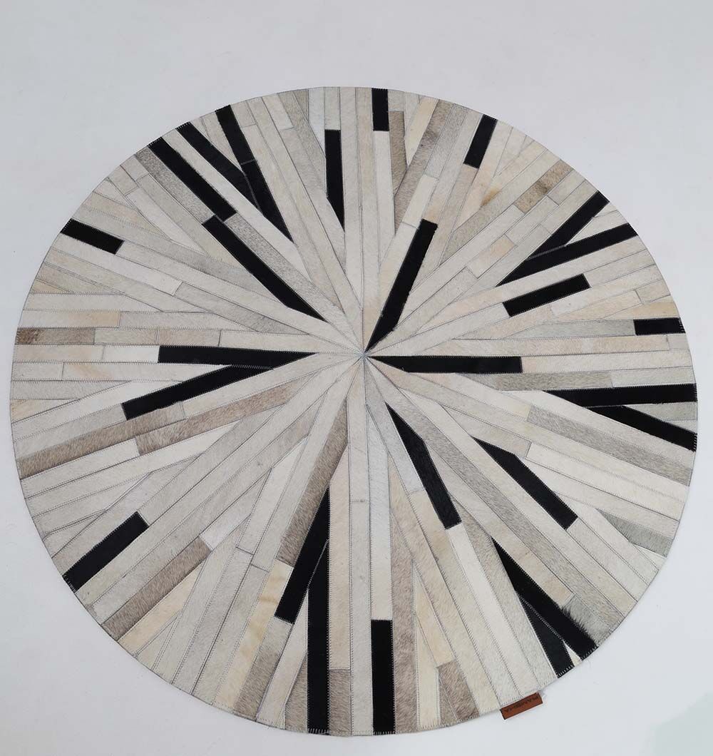 The RAMSHA HOME Stunning Multi Color Dining Room Decor Leather Rug - LR 021 showcases a round design with geometric light beige, gray, and black strips, forming a bold starburst pattern against a white background.