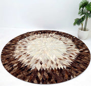 The RAMSHA HOME Multi Color Guest Room Round Decor Leather Rug - LR 022, featuring a geometric starburst pattern in brown, cream, and beige, is placed on a white floor beside a potted green plant against a plain white wall.