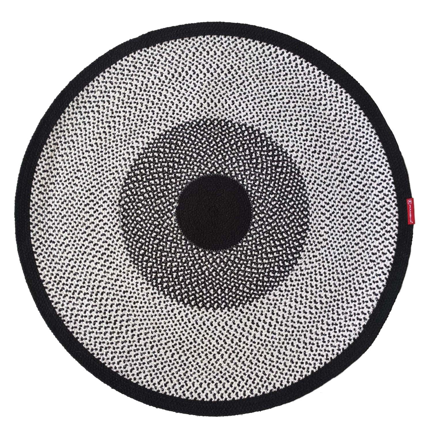 The RAMSHA HOME Black & White Color Round Braided Rug - BR 010 features concentric circles and a textured design radiating from a solid black center, creating a stylish and striking cotton braided round area rug for any space.