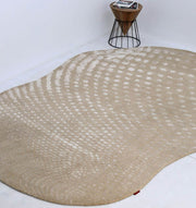 The RAMSHA HOME Shape Floor Rug Multi Color HTWV 93 (200x300 cm), featuring an irregular design with white dots, lies on a white floor beside a small wooden side table holding magazines.