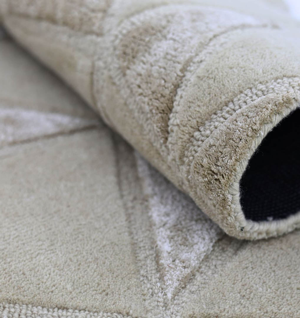A close-up of the RAMSHA HOME Handmade Decor Multi Color Rug HTWV-94, partially rolled to display its textured surface, stitched geometric pattern, and a black backing visible inside the roll.