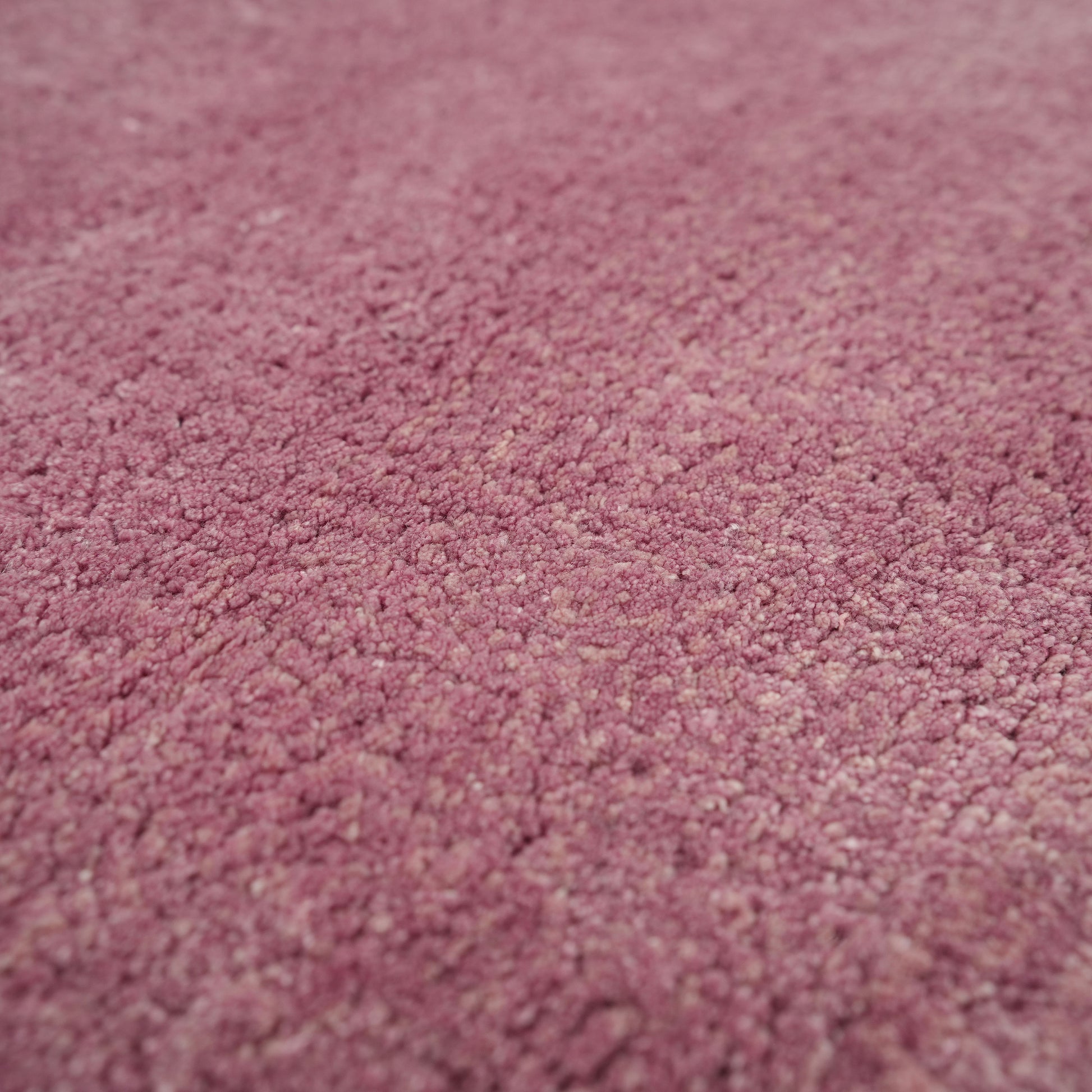 Close-up of the Rose Ombre Handmade Area Rug HTV 27 (300x400 cm) by RAMSHA HOME, highlighting its soft, textured pink Tencel cotton surface with detailed fibers and a plush, gently uneven finish.