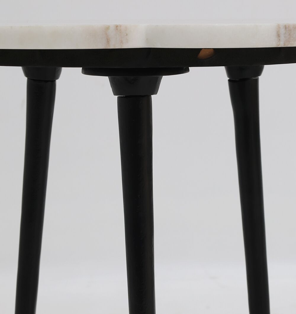 Close-up of the CloudForm Nesting Marble Table by RAMSHA HOME, featuring a white marble top and three black metal legs, styled against a plain light background.