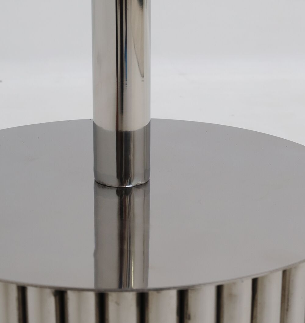 A close-up of the Luna Polished Marble & Steel Side Table by RAMSHA HOME shows its shiny steel cylindrical base with a vertical pole, reflecting light—an elegant foundation for modern decor.