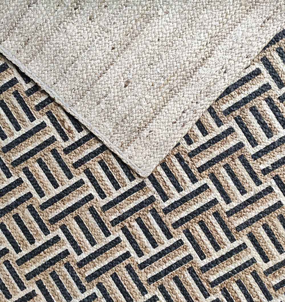 The RAMSHA HOME Jute Printed Rug Area Rug BR-039 is shown in beige jute with a black and tan geometric pattern, one corner flipped to display the solid woven underside.