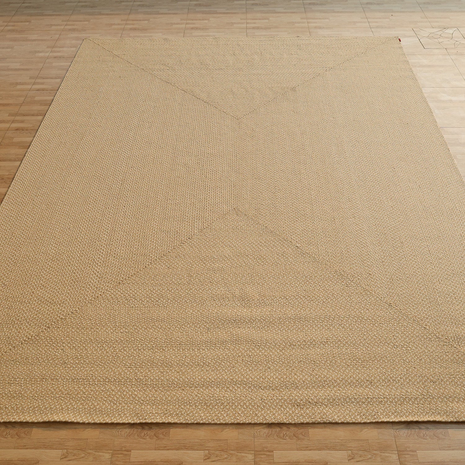 The RAMSHA HOME Natural Color Handmade Rectangle Wool Area Braided Rug - BR 053C features a subtle geometric pattern and beige tones, adding texture and style as it covers most of the light wood floor.