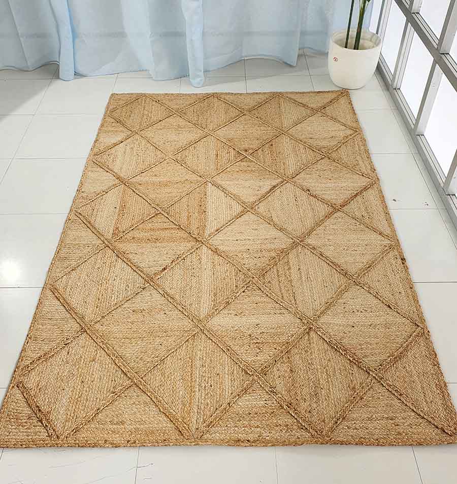 The RAMSHA HOME Amazing Handmade Jute Rug Living Room - BR 084, featuring a rectangular shape and diamond pattern, is placed on a white tiled floor near a potted plant and large windows with light blue curtains.