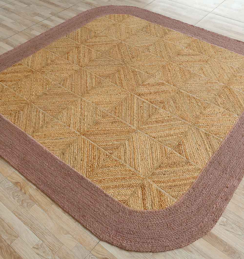 The RAMSHA HOME Natural & Rust Color Braided Outdoor Rug (BR 094) features a square shape with natural fibers and a rust-hued geometric pattern, displayed on a light wood floor.