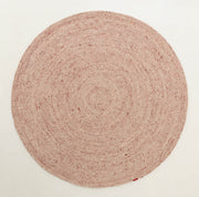 The Soft Pink Braided Wool Area Rug Handmade Circular Rug - BR 099 from RAMSHA HOME is a blush pink, round rug handcrafted from braided wool. Showcasing a delicate spiral pattern and minimalist design, this elegant piece is displayed against a plain white background, highlighting its gentle hue and refined texture.