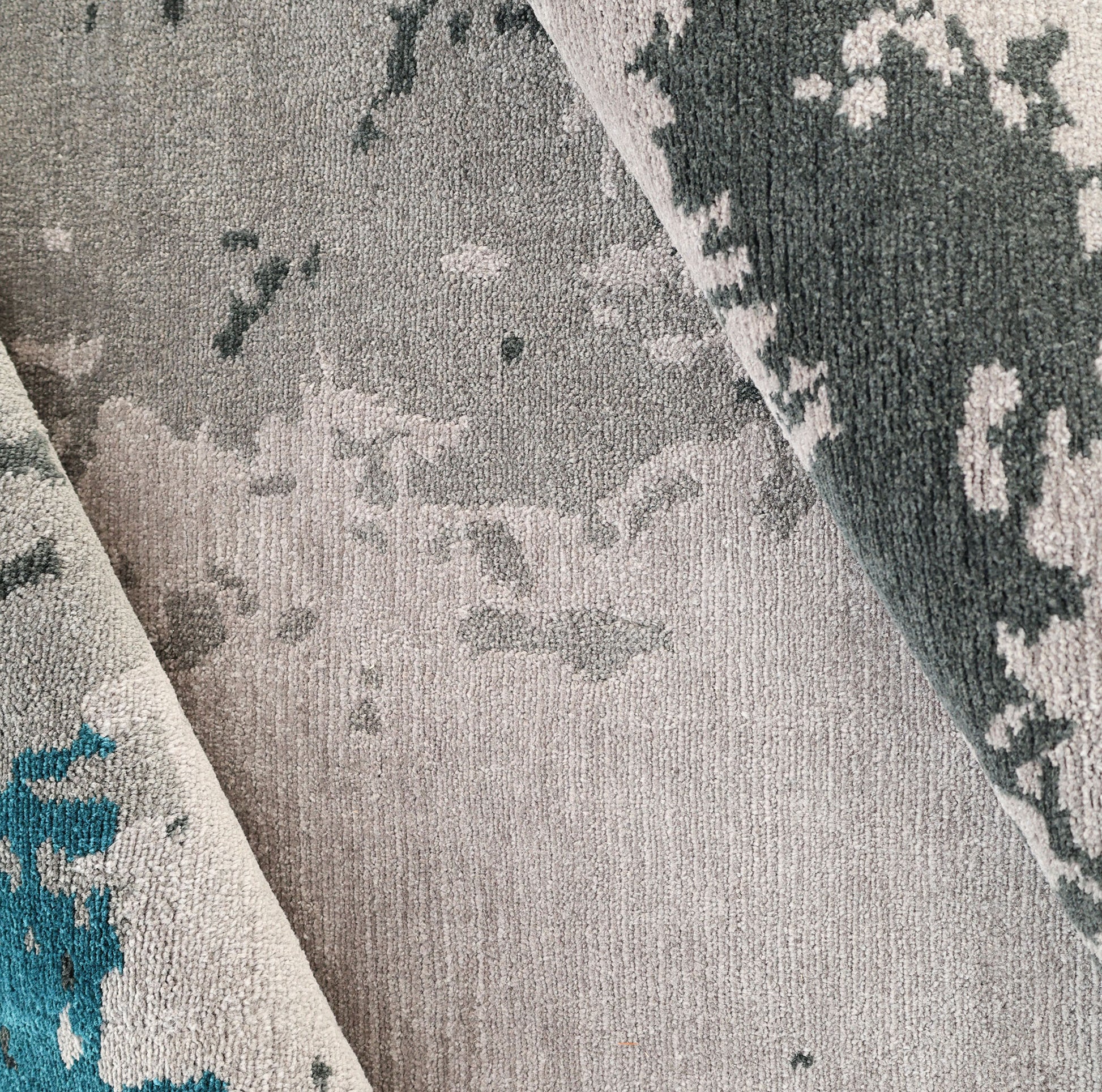 A close-up of the RAMSHA HOME Modern Blue Round Abstract Rug CMN 121, showing its textured geometric patterns in blue-toned shades, with sections of the rug slightly folded over.