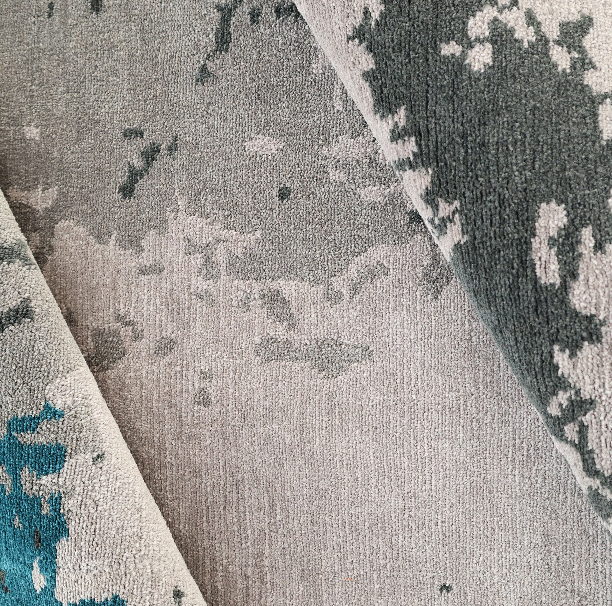 A close-up of the RAMSHA HOME Modern Blue Round Abstract Rug CMN 121, showing its textured geometric patterns in blue-toned shades, with sections of the rug slightly folded over.