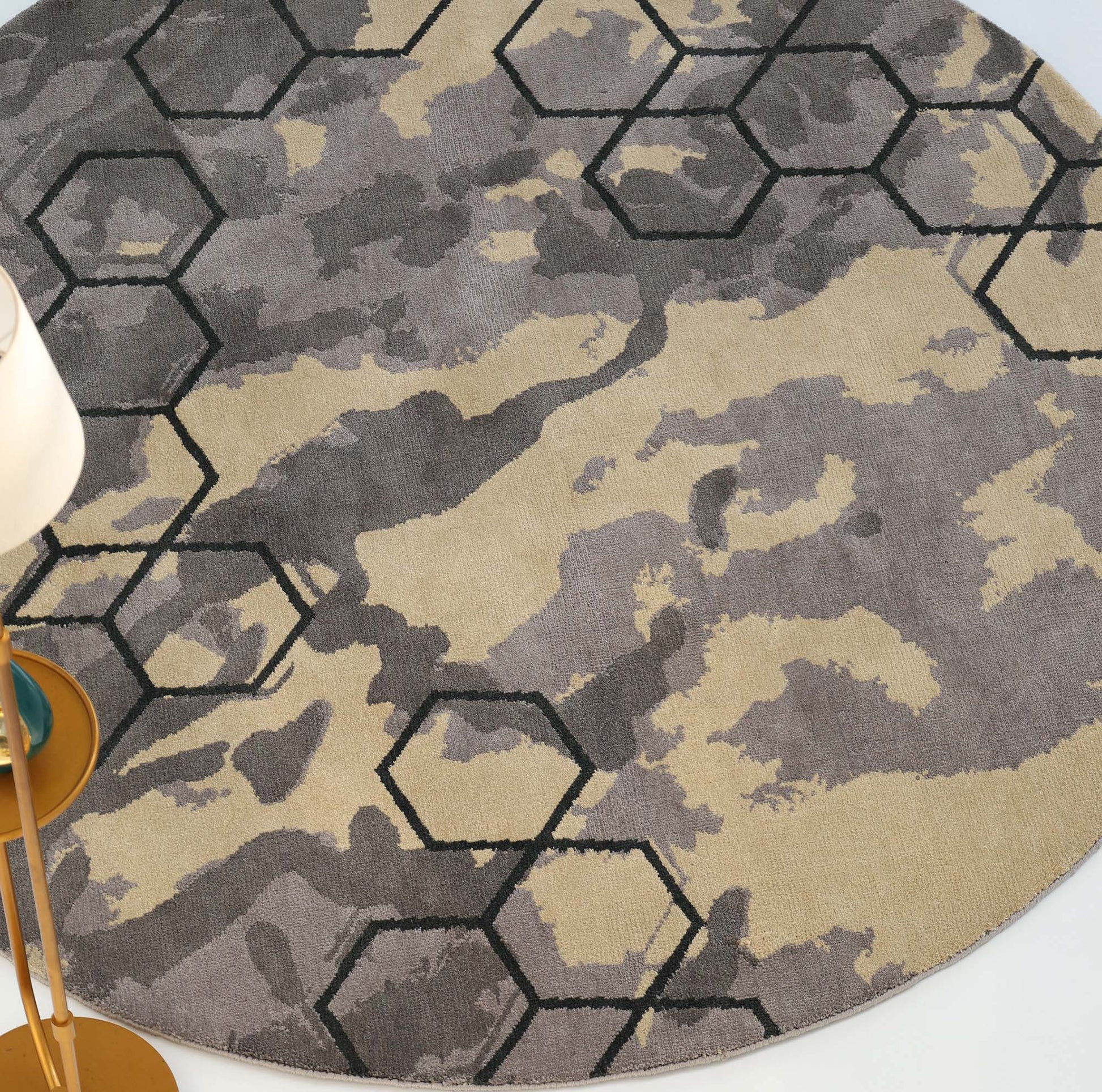 The RAMSHA HOME Modern Geometric Round Rug Grey & Beige Rug CMN 133 features gray and beige camouflage with a black hexagonal grid, paired with a gold floor lamp and white lampshade for a modern abstract look.