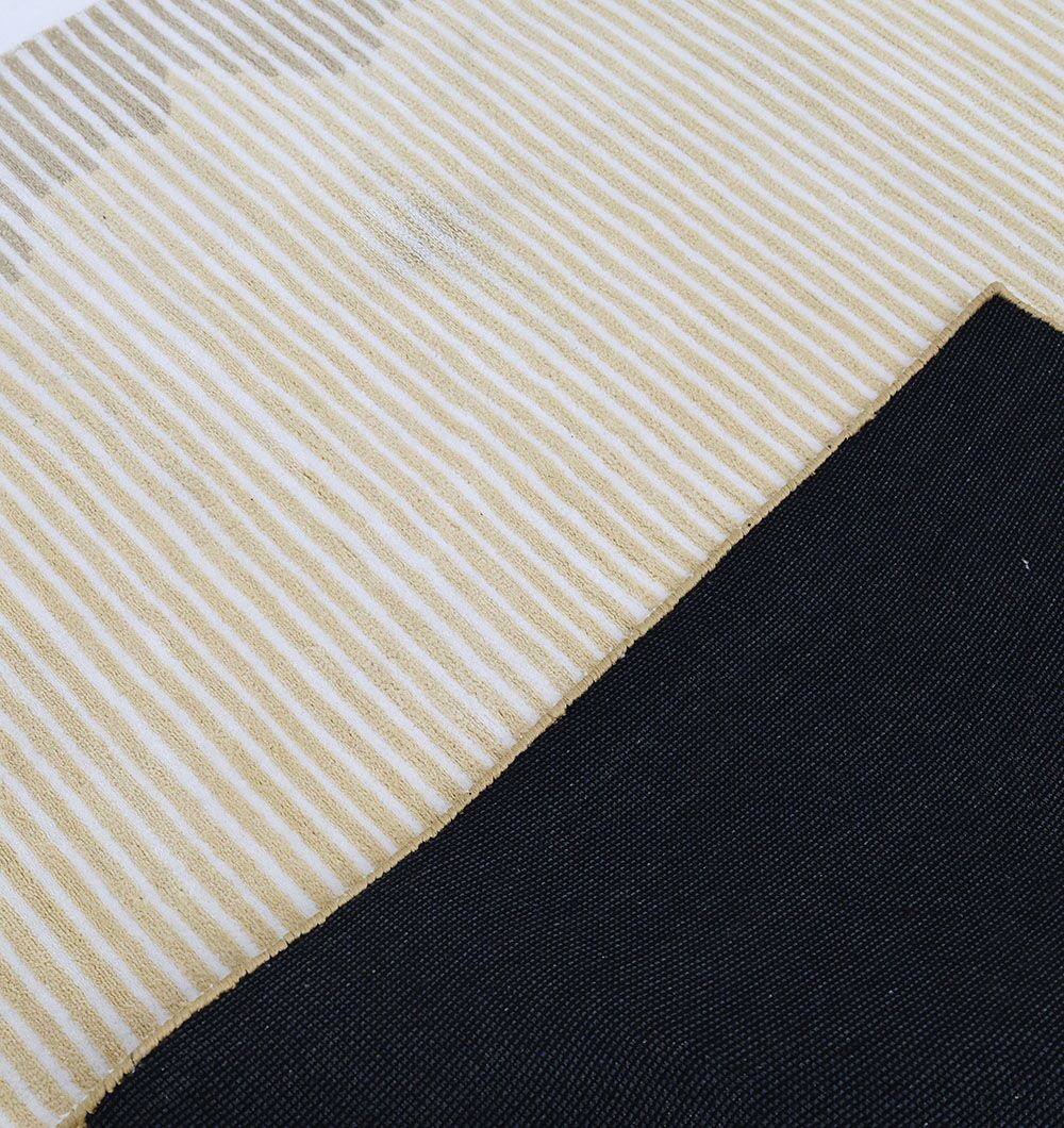 A close-up of RAMSHA HOME's Home Decor Multi Color Novara Rug - CMN 81, featuring diagonal beige and white stripes, overlapped at an angled seam with a solid black fabric.