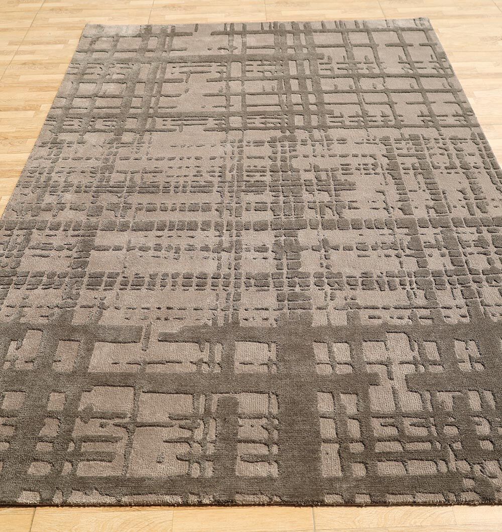 The RAMSHA HOME Indoor Decor Novara Area Rug - CMN 83 (170x240 cm) in taupe features a geometric grid pattern with raised intersecting lines and textured blocks, making it an eye-catching addition to light wood floors.