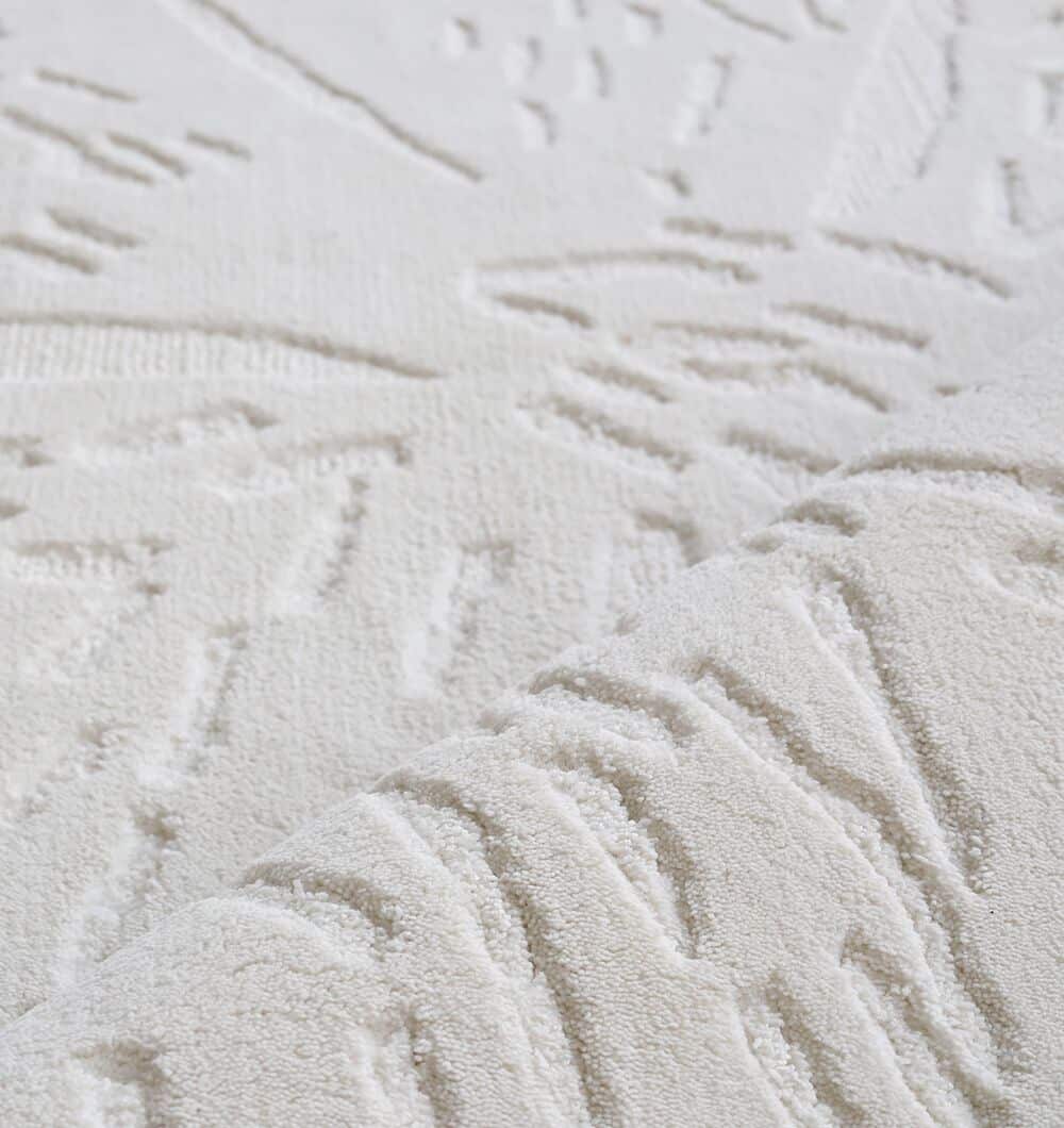 Close-up of the RAMSHA HOME Rectangle Decorative Area Rug - CMN 86 (200x300 cm), showcasing its soft, plush white surface with raised geometric patterns and embossed details for added texture.