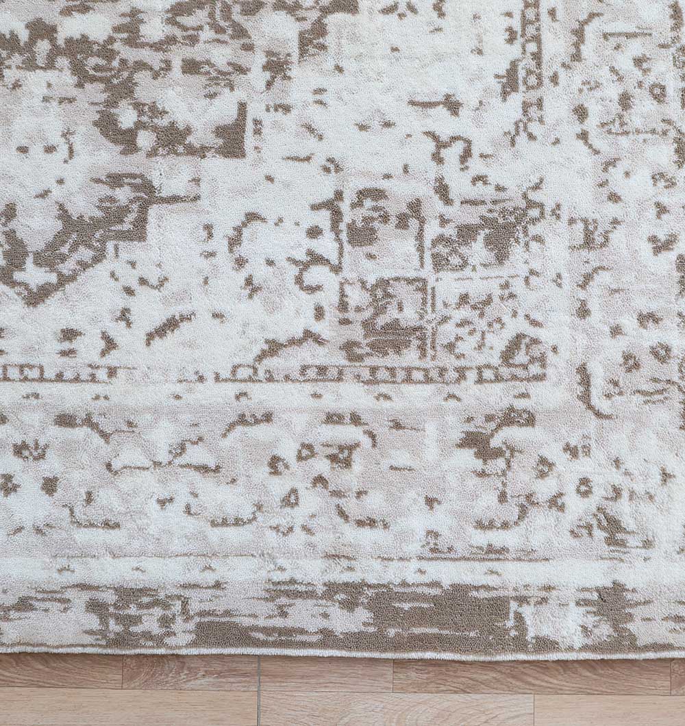 A close-up of the RAMSHA HOME Grey Vintage Style Novara Carpet - CMN 92 displays its abstract, distressed beige and brown patterns and woven texture on a light wooden floor, highlighting the rug’s modern appeal.