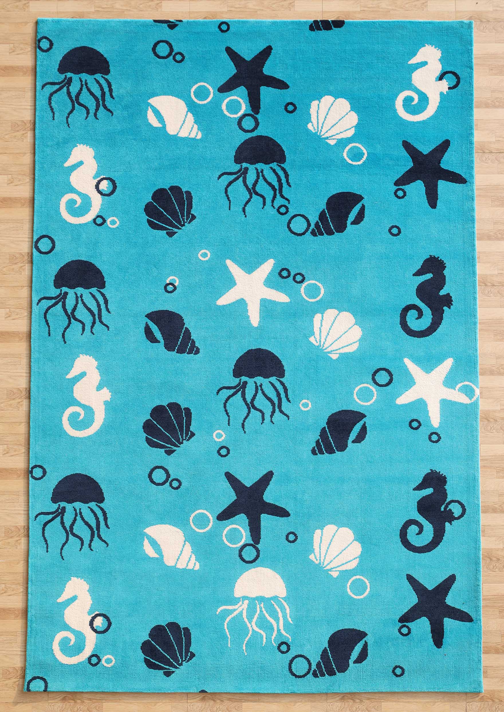 The RAMSHA HOME Ultra Soft Ocean Animals Kids Rug – CMN 100 (200x300 cm) in turquoise, with white and navy sea creatures, brings playful charm to any kids’ room décor, especially when styled on a wooden floor.