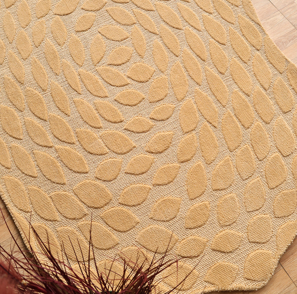 A close-up of the RAMSHA HOME Autumn Leaf Organic Shaped Rug Beige CMN 103, featuring a beige and tan raised leaf pattern on a wooden floor, with reddish-brown decorative dried grass partially in view.