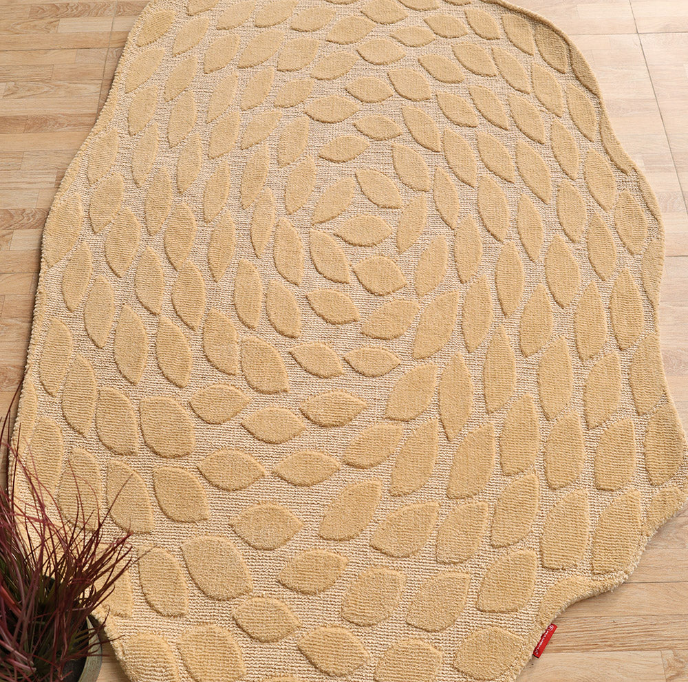 The RAMSHA HOME Autumn Leaf Organic Shaped Rug Beige CMN 103, featuring a textured leaf pattern, adds earthy tones to a light wooden floor. A small plant with reddish leaves in the corner complements the rug’s natural design.